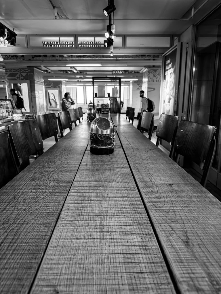 A long communal wooden table inside the café, late afternoon light